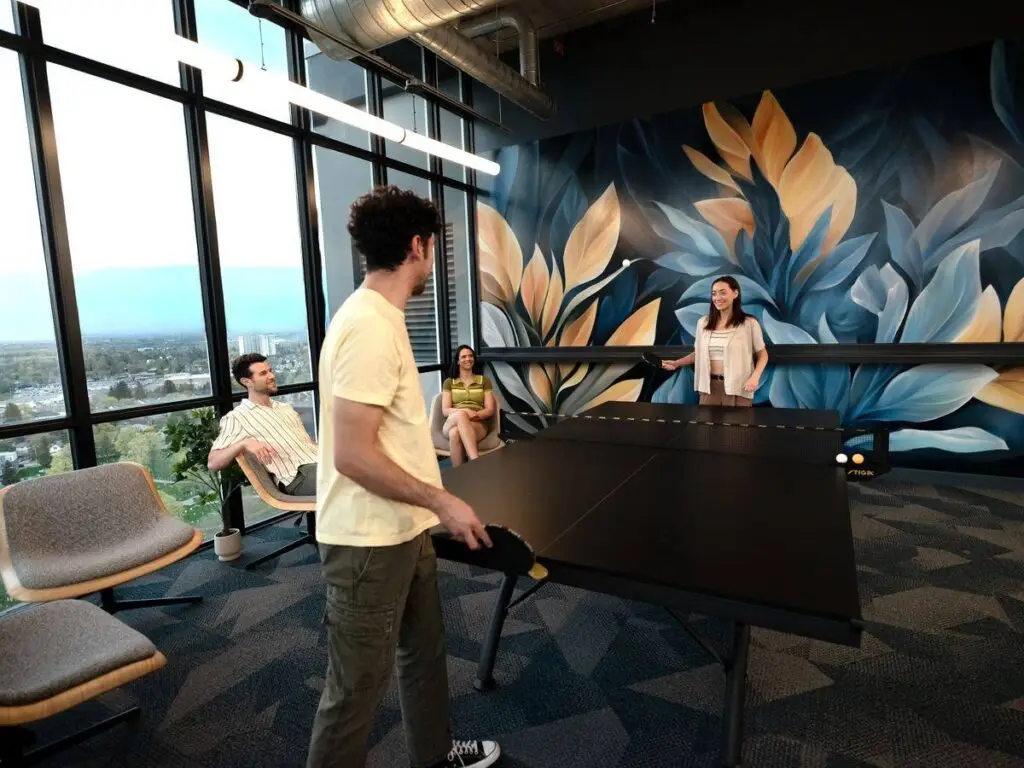 Residents playing ping pong in the games room beside the mural